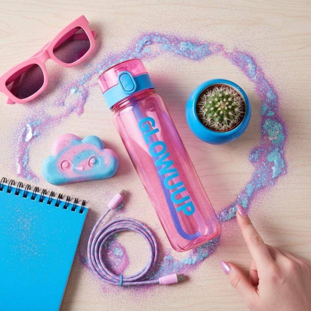 "Top-down view of influencer's collab haul with glitter: water bottle, soap, cactus."